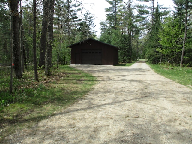 5622 Vacationland Dr, Lewiston, MI 49756 - detached garage featuring driveway and a view of trees
