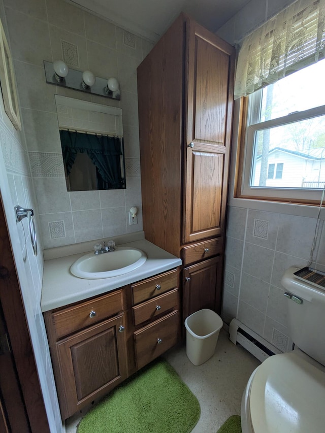 6783 E Houghton Lake Dr, Houghton Lake, MI 48629 - half bath with tile walls, vanity, toilet, a baseboard heating unit, and backsplash