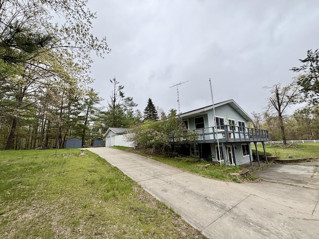 5356 Spruce Dr, Lewiston, MI 49756 - view of front of property with a deck, a front lawn, concrete driveway, and an outdoor structure