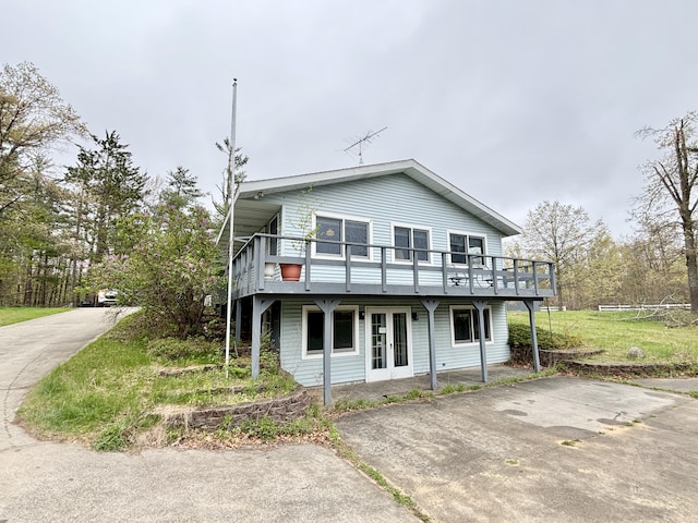 5356 Spruce Dr, Lewiston, MI 49756 - view of front facade with driveway, french doors, and a wooden deck