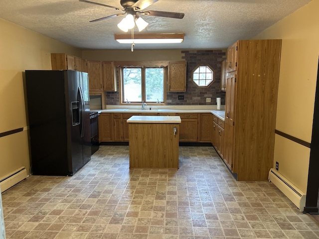 2323 Hobbs Dr, Alpena, MI 49707 - kitchen with black appliances, a textured ceiling, a baseboard heating unit, a ceiling fan, and light countertops