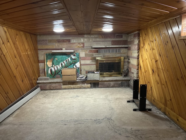 2323 Hobbs Dr, Alpena, MI 49707 - basement with a stone fireplace, wooden walls, wood ceiling, and a baseboard heating unit