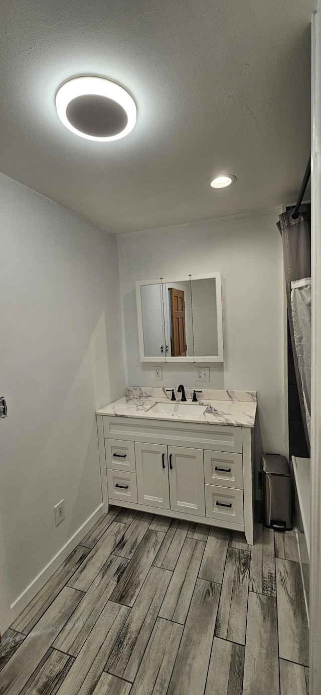 2460 Hamilton Rd, Alpena, MI 49707 - bathroom with wood finish floors, vanity, baseboards, shower / bath combination with curtain, and recessed lighting