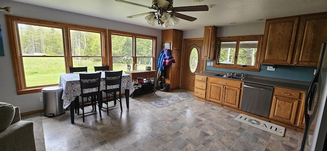 2460 Hamilton Rd, Alpena, MI 49707 - kitchen featuring dishwasher, a ceiling fan, brown cabinets, stone finish floors, and black fridge
