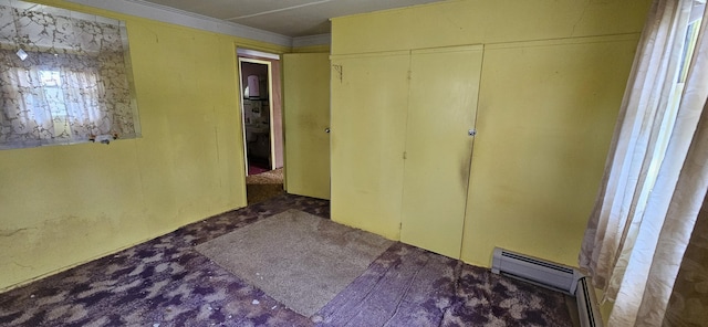 501 Sheridan St, Alpena, MI 49707 - unfurnished bedroom with a closet, crown molding, carpet flooring, and a baseboard heating unit