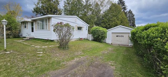 501 Sheridan St, Alpena, MI 49707 - view of property exterior featuring an outbuilding, a detached garage, a yard, and driveway
