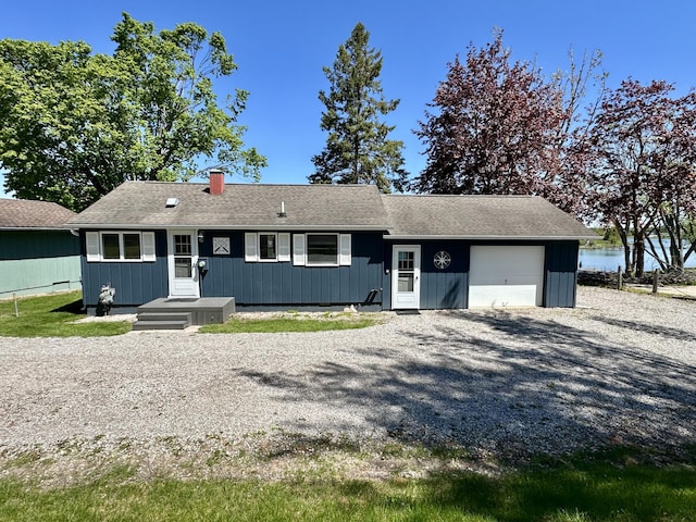 9452 M33, Cheboygan, MI 49721 - ranch-style house featuring a garage, driveway, a chimney, and a shingled roof