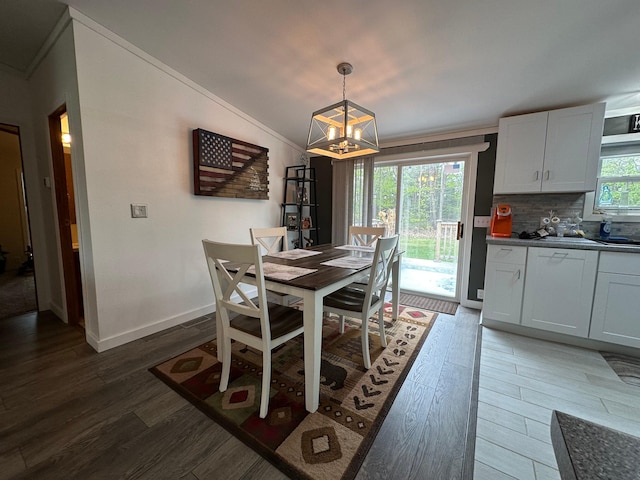 1085 Five Lakes Rd, Gaylord, MI 49735 - dining space with dark wood-style flooring, a chandelier, baseboards, ornamental molding, and vaulted ceiling