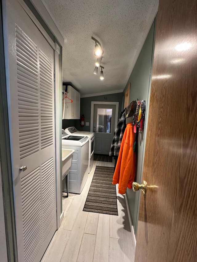 1085 Five Lakes Rd, Gaylord, MI 49735 - laundry area featuring cabinet space, washing machine and dryer, light wood-type flooring, a textured ceiling, and track lighting