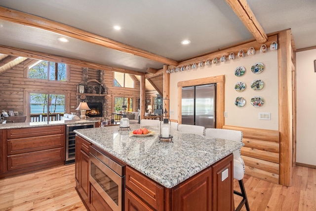 10924 E Grand Lake Rd, Presque Isle, MI 49777 - kitchen featuring stainless steel appliances, beverage cooler, beamed ceiling, light wood-style floors, and log walls