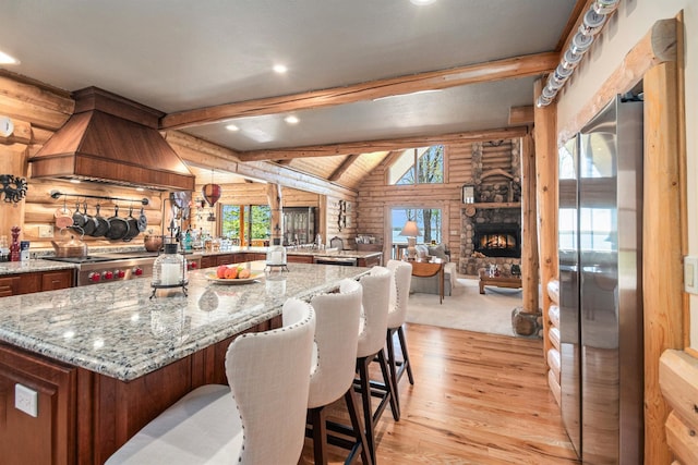 10924 E Grand Lake Rd, Presque Isle, MI 49777 - kitchen featuring log walls, stainless steel appliances, premium range hood, light wood-style flooring, and recessed lighting