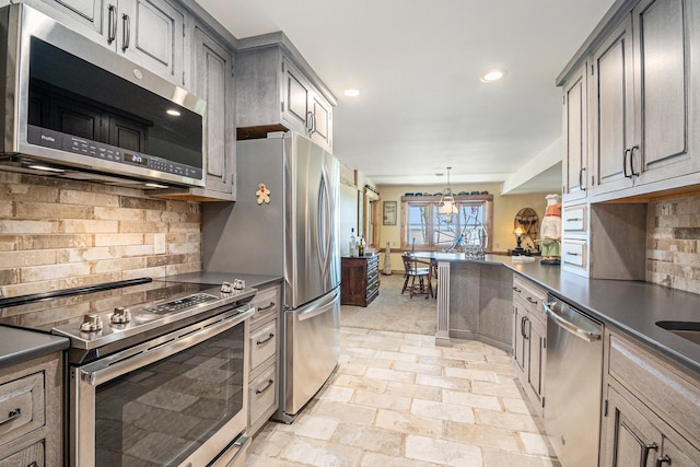 10924 E Grand Lake Rd, Presque Isle, MI 49777 - kitchen featuring stainless steel appliances, dark countertops, backsplash, recessed lighting, and hanging light fixtures