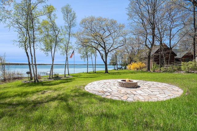 10924 E Grand Lake Rd, Presque Isle, MI 49777 - view of green lawn featuring a fire pit, a water view, and a patio area
