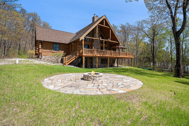 10924 E Grand Lake Rd, Presque Isle, MI 49777 - back of house with log siding, a fire pit, a chimney, a deck, and a yard