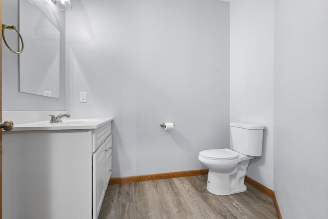 4348 W Lakeside Dr, West Branch, MI 48661 - bathroom featuring wood finished floors, vanity, toilet, and baseboards