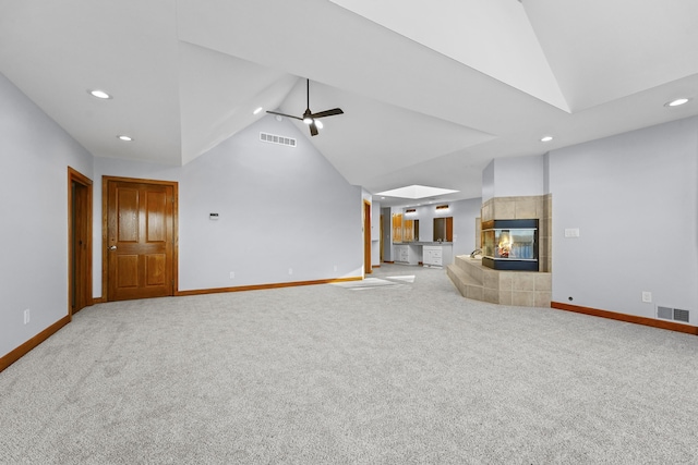 4348 W Lakeside Dr, West Branch, MI 48661 - unfurnished living room featuring lofted ceiling, baseboards, recessed lighting, carpet floors, and a tiled fireplace