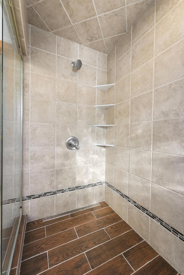 4348 W Lakeside Dr, West Branch, MI 48661 - bathroom featuring tiled shower and wood finished floors