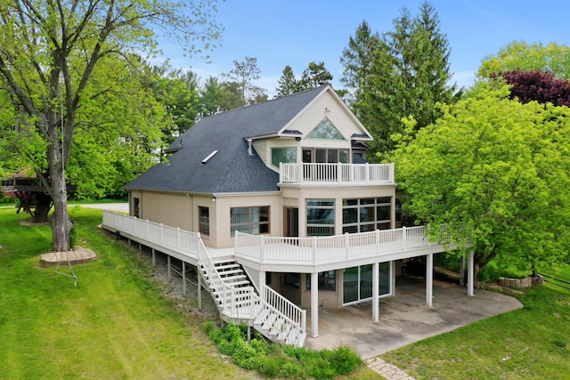 4348 W Lakeside Dr, West Branch, MI 48661 - back of property featuring a balcony, a lawn, a patio, a shingled roof, and a wooden deck