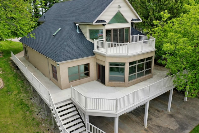 4348 W Lakeside Dr, West Branch, MI 48661 - back of property featuring a balcony, a shingled roof, and brick siding