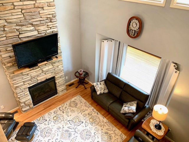 132 16th St, Prudenville, MI 48651 - living room with a fireplace, wood finished floors, baseboards, and plenty of natural light