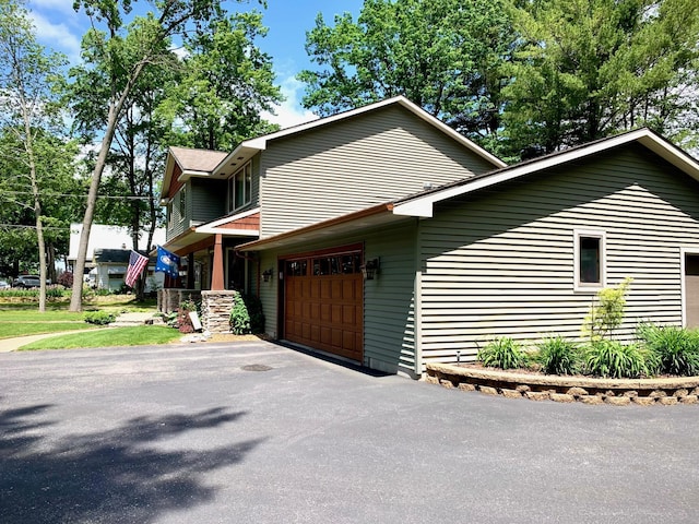 132 16th St, Prudenville, MI 48651 - view of side of property featuring asphalt driveway and a garage