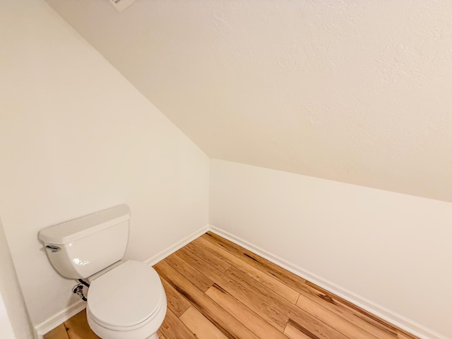 116 No Wake Ct, Houghton Lake, MI 48629 - bathroom featuring toilet, lofted ceiling, wood finished floors, and baseboards