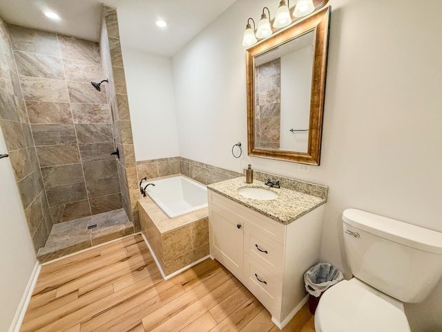 116 No Wake Ct, Houghton Lake, MI 48629 - full bath featuring a garden tub, vanity, wood finished floors, toilet, and a tile shower
