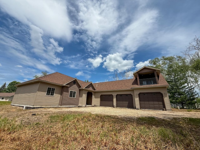 116 No Wake Ct, Houghton Lake, MI 48629 - view of front of property with dirt driveway, an attached garage, roof with shingles, and a balcony