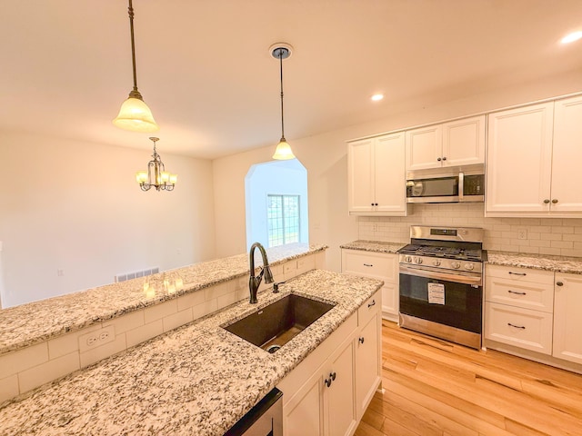 116 No Wake Ct, Houghton Lake, MI 48629 - kitchen featuring appliances with stainless steel finishes, a sink, light wood-style flooring, backsplash, and recessed lighting