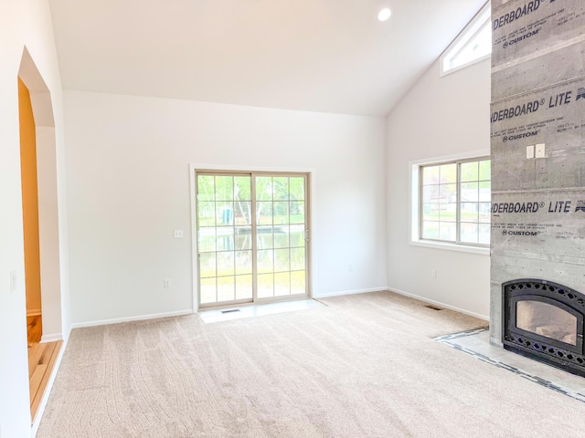 116 No Wake Ct, Houghton Lake, MI 48629 - unfurnished living room featuring high vaulted ceiling, healthy amount of natural light, carpet floors, and baseboards
