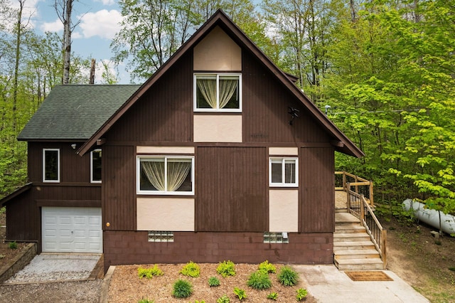 6192 Wilderness Dr, Mancelona, MI 49659 - view of front facade featuring a shingled roof, a garage, and crawl space