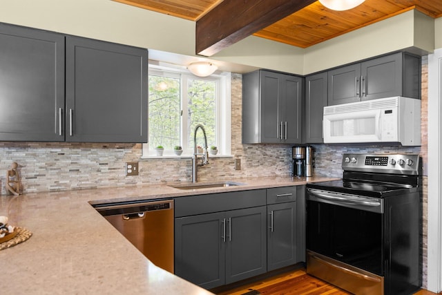 6192 Wilderness Dr, Mancelona, MI 49659 - kitchen with appliances with stainless steel finishes, a sink, wooden ceiling with exposed beams, backsplash, and gray cabinets