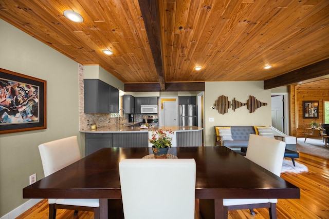6192 Wilderness Dr, Mancelona, MI 49659 - dining space with light wood finished floors, wooden ceiling with exposed beams, recessed lighting, and baseboards