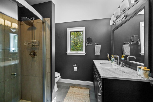 6192 Wilderness Dr, Mancelona, MI 49659 - bathroom with vanity, a shower stall, toilet, baseboards, and tile patterned flooring