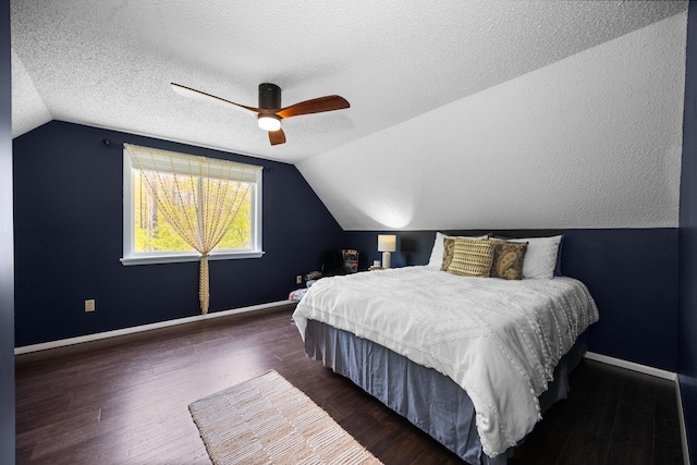 6192 Wilderness Dr, Mancelona, MI 49659 - bedroom with vaulted ceiling, baseboards, wood finished floors, a ceiling fan, and a textured ceiling