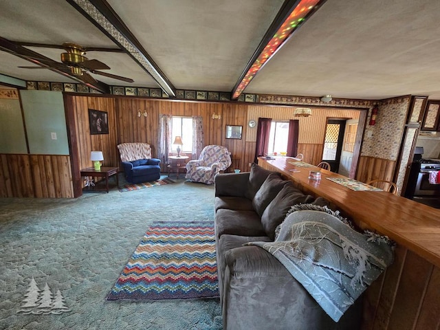 3557 Penn Rd, Lewiston, MI 49756 - carpeted living area featuring beam ceiling, wood walls, and ceiling fan