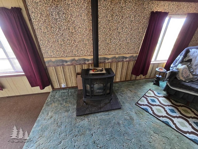 3557 Penn Rd, Lewiston, MI 49756 - carpeted living area with a wood stove and wood walls