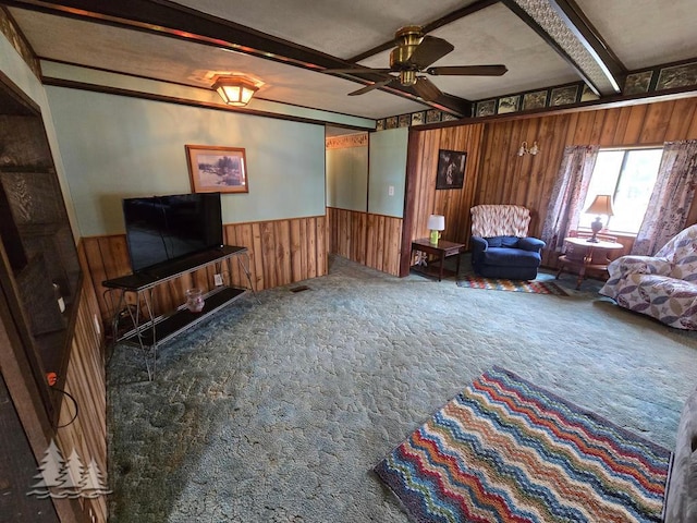 3557 Penn Rd, Lewiston, MI 49756 - carpeted living room featuring beamed ceiling, wood walls, a ceiling fan, and a wainscoted wall