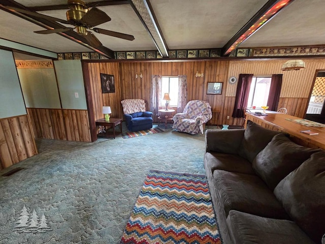 3557 Penn Rd, Lewiston, MI 49756 - living room featuring beamed ceiling, wooden walls, healthy amount of natural light, a ceiling fan, and carpet flooring