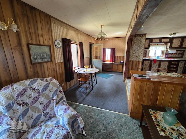 3557 Penn Rd, Lewiston, MI 49756 - carpeted dining area featuring wood walls and a chandelier