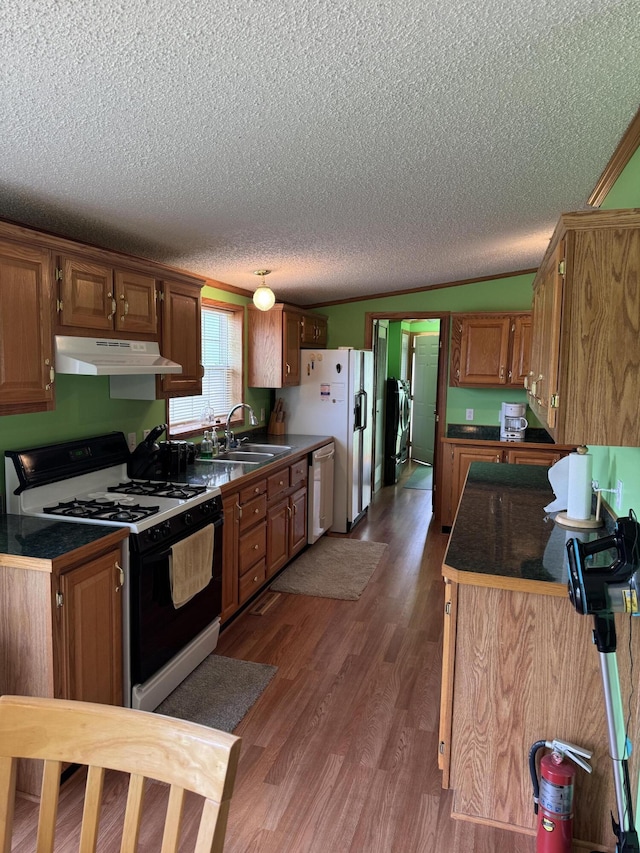 1154 M-72 W, Barton City, MI 48705 - kitchen featuring gas stove, under cabinet range hood, a sink, a textured ceiling, and dark countertops