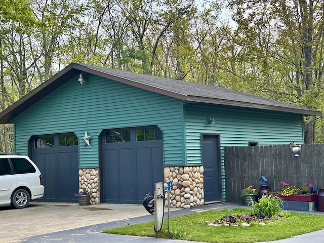 3334 Pleasant View Dr, Lewiston, MI 49756 - view of side of home featuring stone siding, a garage, an outdoor structure, and driveway