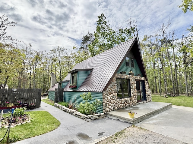 3334 Pleasant View Dr, Lewiston, MI 49756 - view of property exterior with stone siding and metal roof