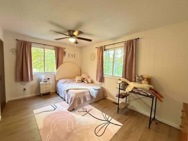 116 1st St, Hubbard Lake, MI 49747 - bedroom with light wood-type flooring, baseboards, and ceiling fan