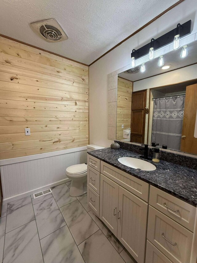 116 1st St, Hubbard Lake, MI 49747 - full bathroom with toilet, wooden walls, vanity, marble look tile flooring, and a textured ceiling