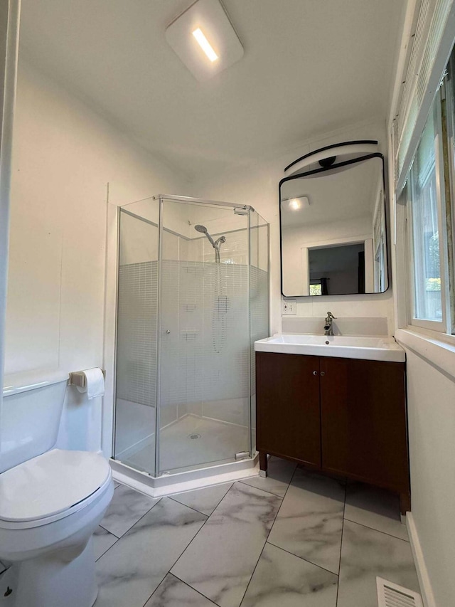 116 1st St, Hubbard Lake, MI 49747 - bathroom featuring vanity, toilet, marble look tiles, and a shower stall