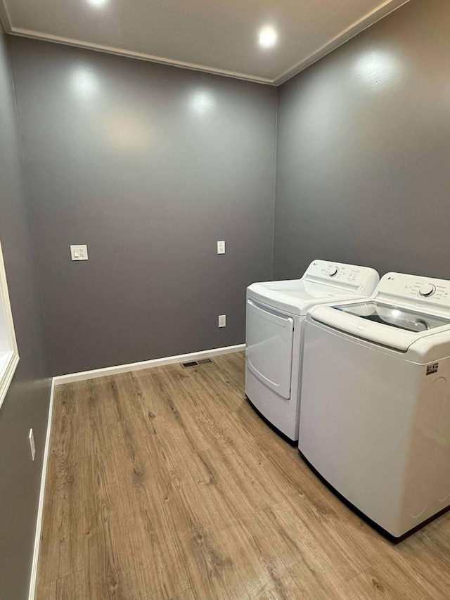 116 1st St, Hubbard Lake, MI 49747 - laundry area with light wood-style floors, washing machine and clothes dryer, and baseboards