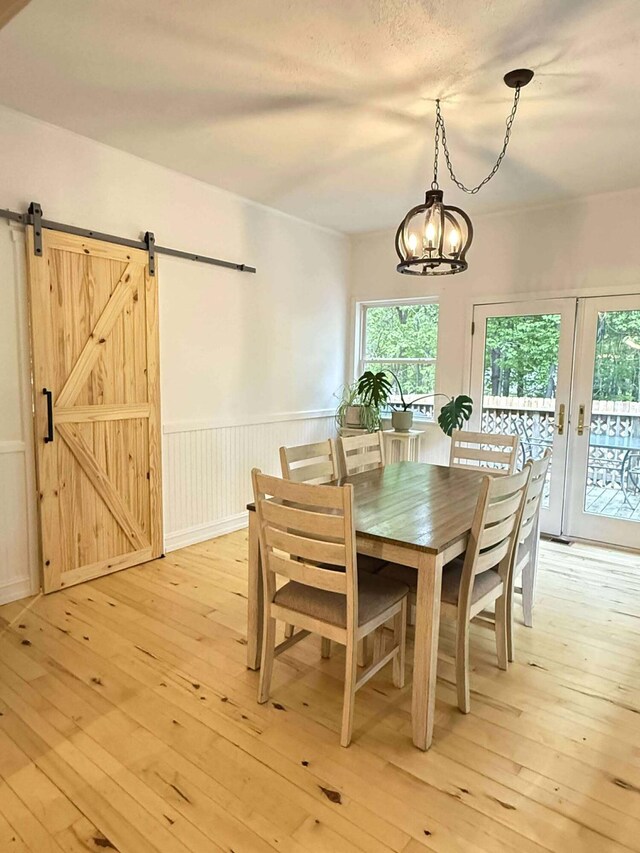 116 1st St, Hubbard Lake, MI 49747 - dining room with plenty of natural light, light wood-style floors, a chandelier, and wainscoting