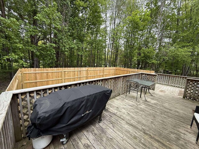 116 1st St, Hubbard Lake, MI 49747 - deck featuring a fenced backyard, outdoor dining space, and a grill