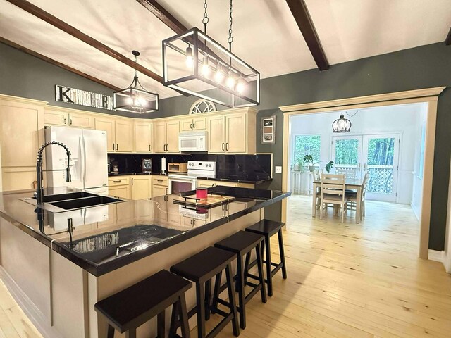 116 1st St, Hubbard Lake, MI 49747 - kitchen with white appliances, beam ceiling, decorative backsplash, a breakfast bar area, and light wood-style floors